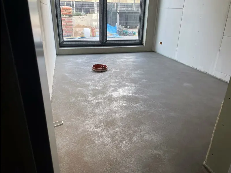 Abgezogener Estrich in einem Raum mit bodentiefem Fenster