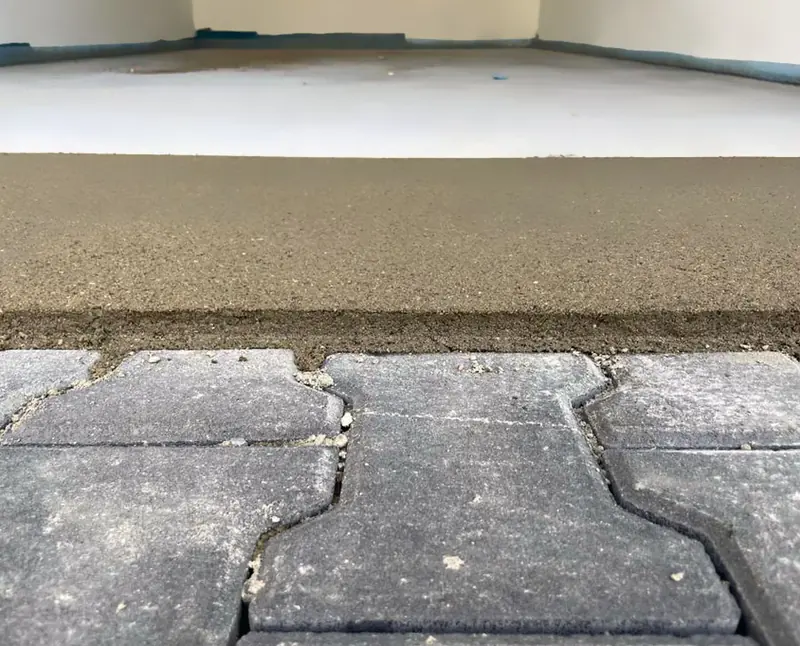 Detailaufnahme einer Estrichkante auf einer Pflasterfläche