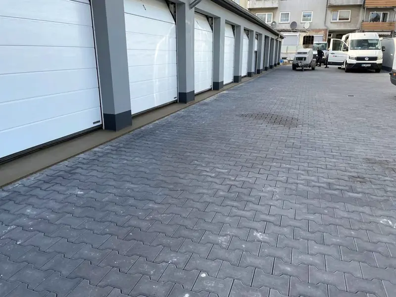 Gepflasterte Zufahrt vor einer Garagenreihe